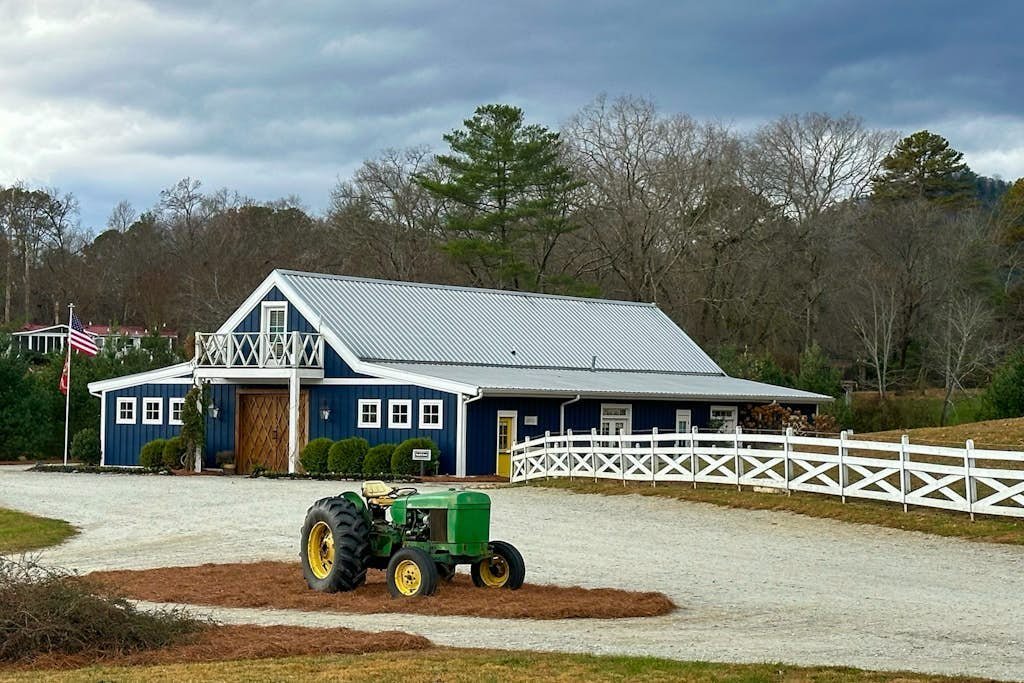 Exterior view of King Mountain Retreat with the blue mountain house and tractor